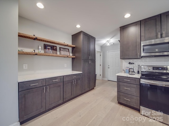 kitchen with tasteful backsplash, dark brown cabinetry, appliances with stainless steel finishes, and light wood-type flooring