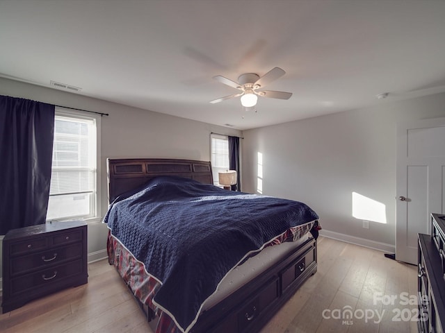 bedroom featuring ceiling fan, multiple windows, and light wood-type flooring