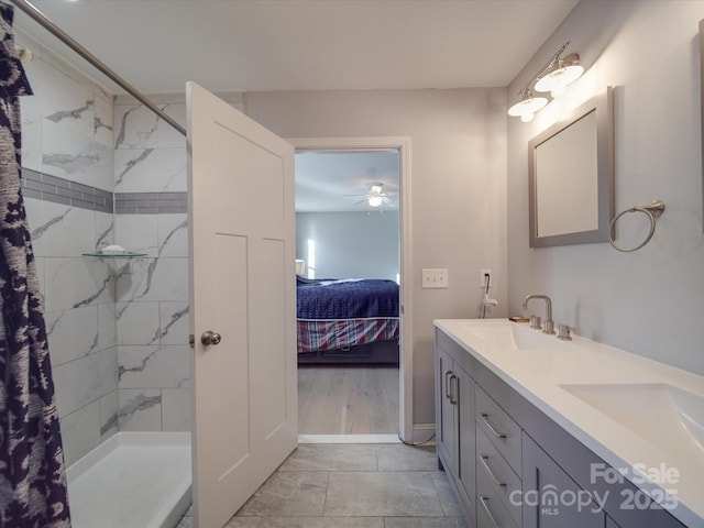 bathroom featuring ceiling fan, tiled shower, and vanity