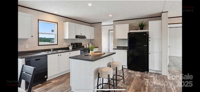 kitchen with black appliances, a center island, white cabinetry, and ornamental molding