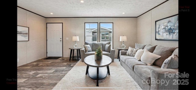 living room with a textured ceiling, ornamental molding, and hardwood / wood-style floors