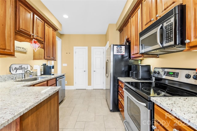 kitchen featuring sink, appliances with stainless steel finishes, and light stone counters