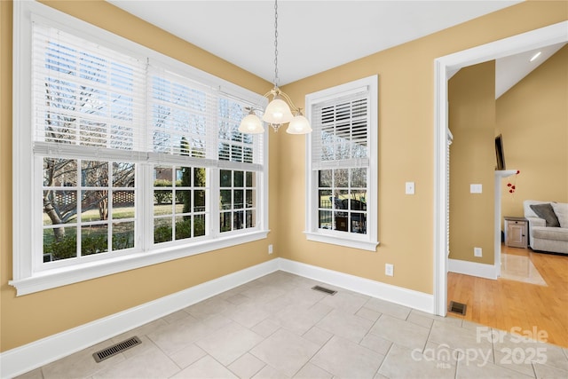 unfurnished dining area featuring an inviting chandelier