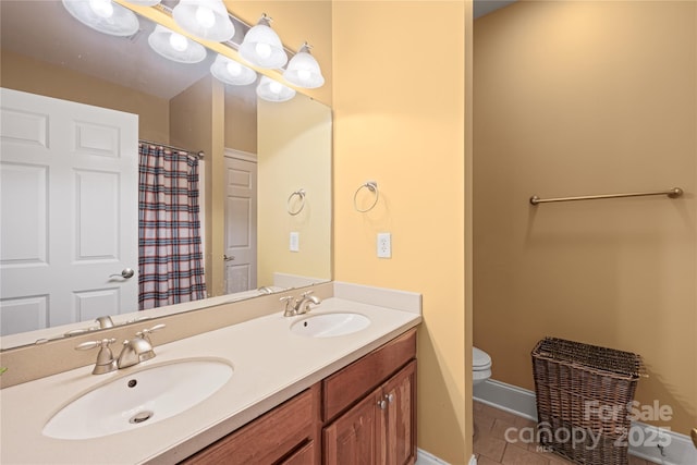 bathroom featuring toilet, vanity, and tile patterned flooring