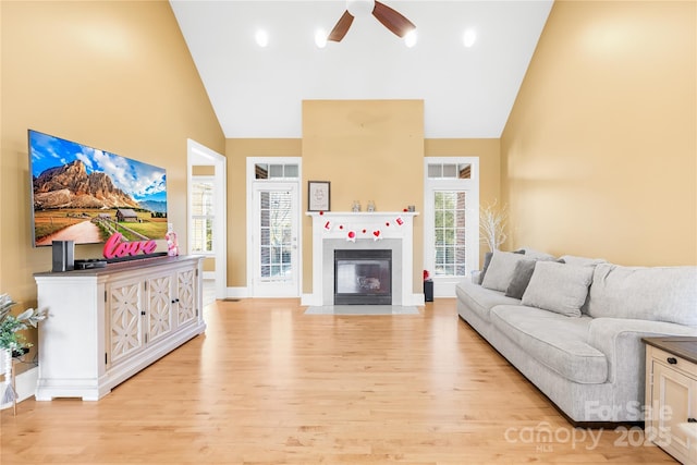 living room with high vaulted ceiling, light hardwood / wood-style flooring, and ceiling fan