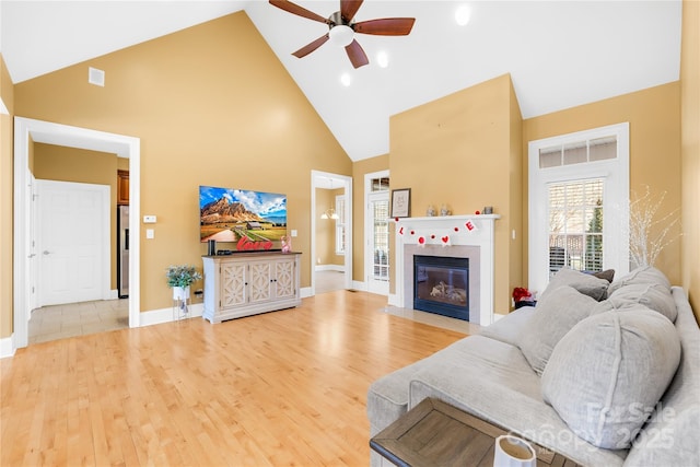 living room featuring high vaulted ceiling, light hardwood / wood-style flooring, and ceiling fan