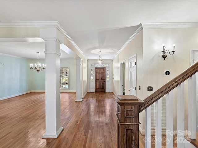 foyer entrance with baseboards, stairway, ornate columns, and wood finished floors