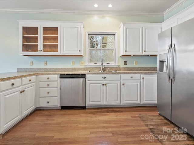 kitchen featuring stainless steel appliances, white cabinets, and a sink