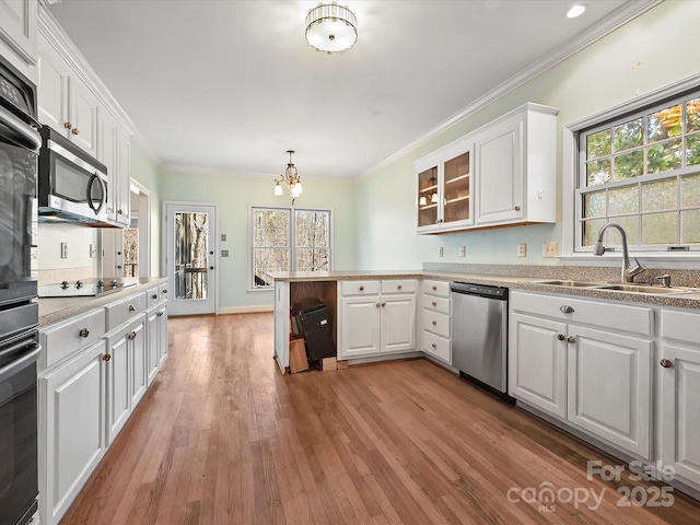 kitchen with stainless steel appliances, a sink, glass insert cabinets, and white cabinets