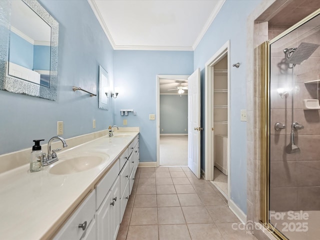 full bathroom with tile patterned flooring, crown molding, a sink, and a shower stall