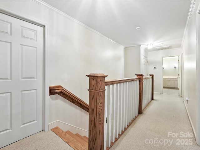 hall featuring baseboards, ornamental molding, an upstairs landing, and light colored carpet