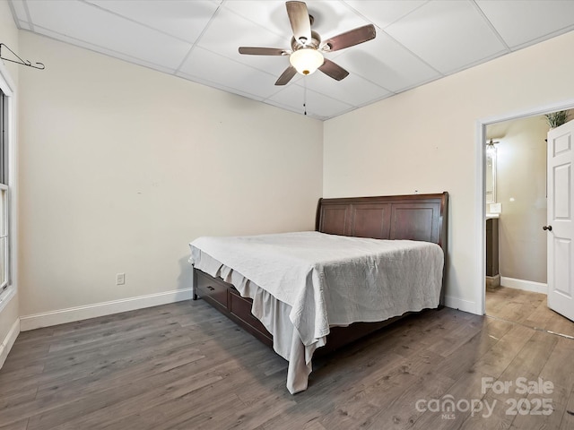 bedroom with ceiling fan, dark wood-type flooring, a paneled ceiling, and baseboards