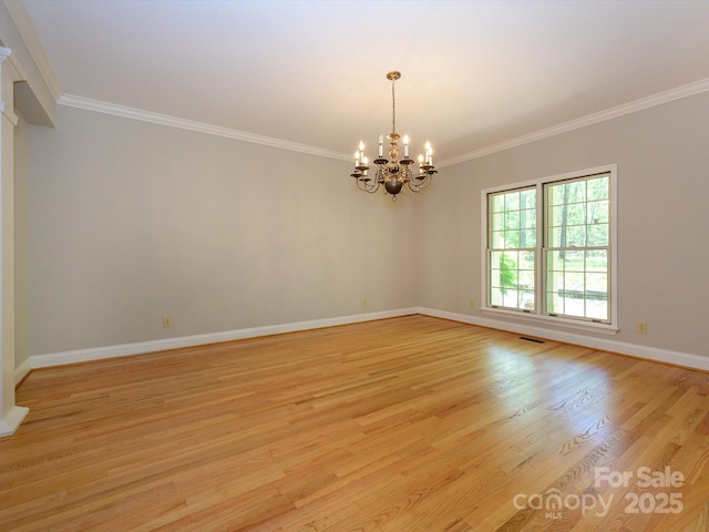 empty room with visible vents, light wood-style floors, a chandelier, and crown molding