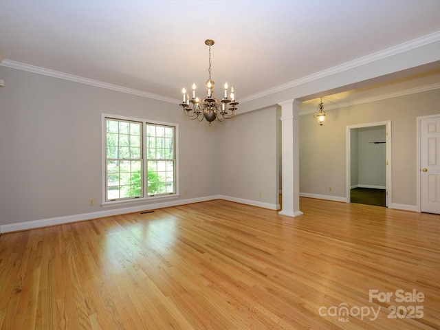 unfurnished room featuring a chandelier, light wood finished floors, crown molding, and ornate columns
