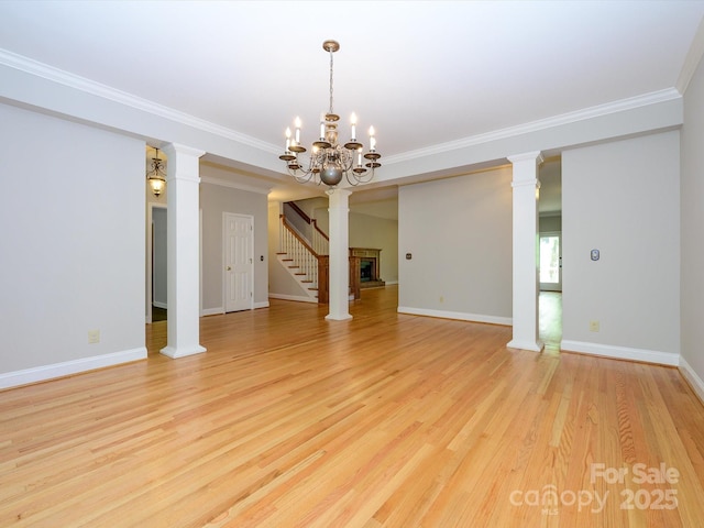 unfurnished dining area featuring an inviting chandelier, crown molding, light wood-style floors, and baseboards