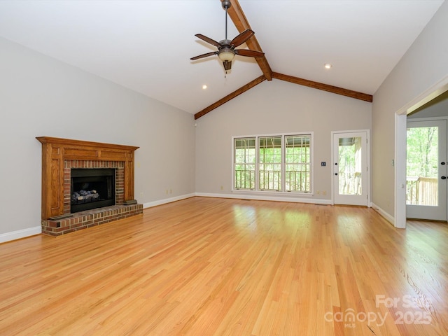 unfurnished living room with plenty of natural light, ceiling fan, beam ceiling, and light wood-style floors