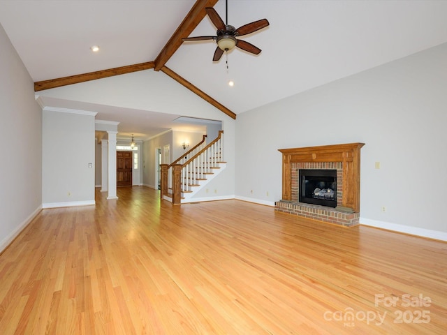 unfurnished living room with a ceiling fan, stairs, light wood finished floors, baseboards, and a brick fireplace
