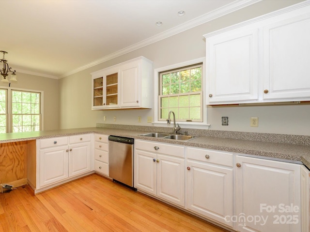 kitchen featuring stainless steel dishwasher, ornamental molding, a sink, light wood-style floors, and white cabinetry