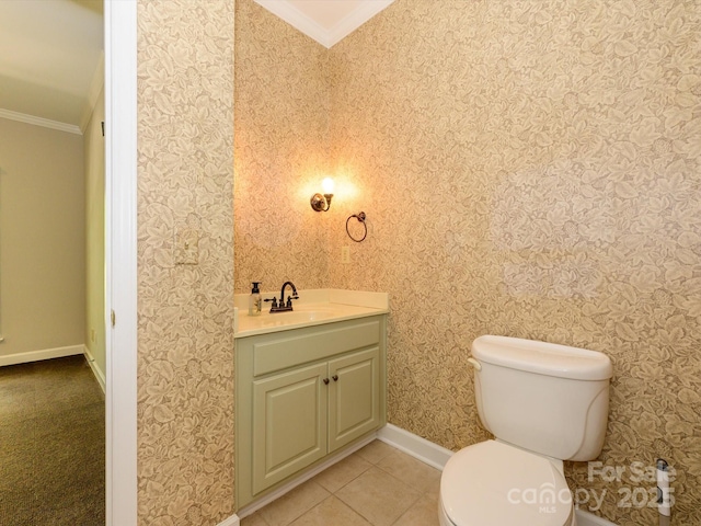 bathroom featuring toilet, baseboards, tile patterned flooring, vanity, and ornamental molding