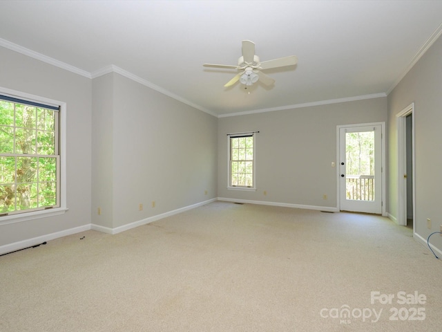 spare room with baseboards, ornamental molding, and light colored carpet