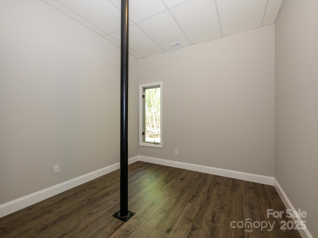 empty room with baseboards, dark wood-style flooring, and visible vents