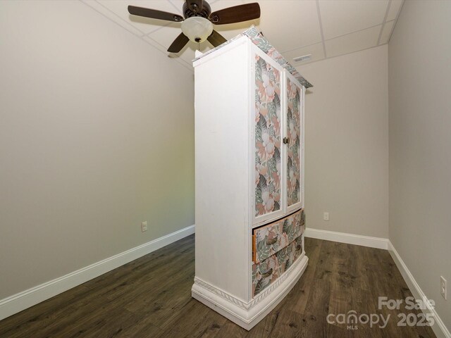 interior space with a ceiling fan, wood finished floors, visible vents, baseboards, and a paneled ceiling