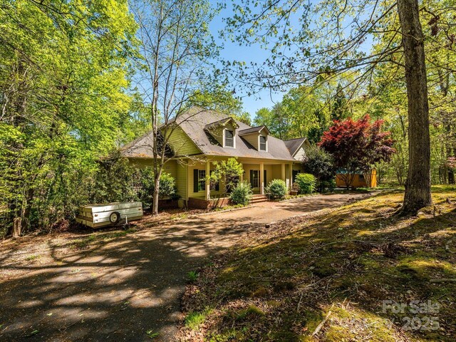view of front facade with dirt driveway and a porch
