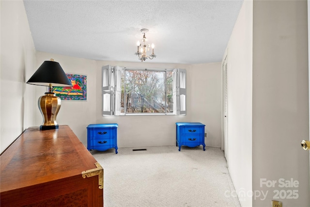 interior space featuring carpet, a notable chandelier, and a textured ceiling