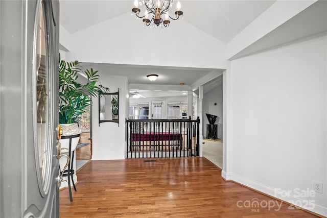 entrance foyer featuring vaulted ceiling, ceiling fan with notable chandelier, and hardwood / wood-style flooring