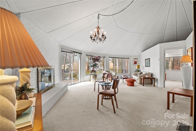 carpeted living room with plenty of natural light and a notable chandelier