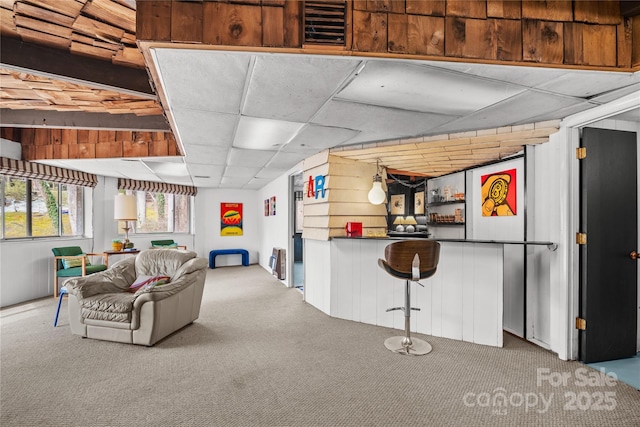 carpeted living room with a paneled ceiling