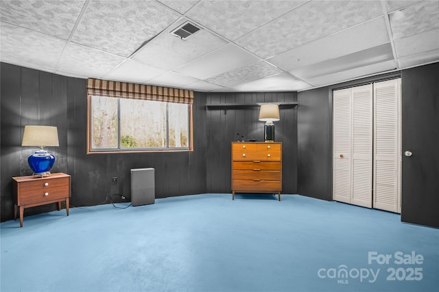 interior space featuring a closet, wood walls, and concrete flooring