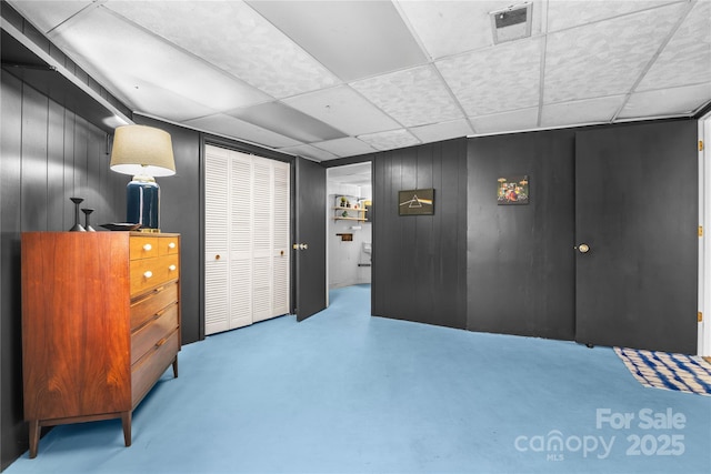 bedroom with a paneled ceiling and wooden walls