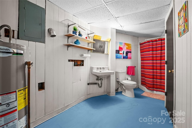 bathroom featuring water heater, toilet, concrete floors, electric panel, and a drop ceiling