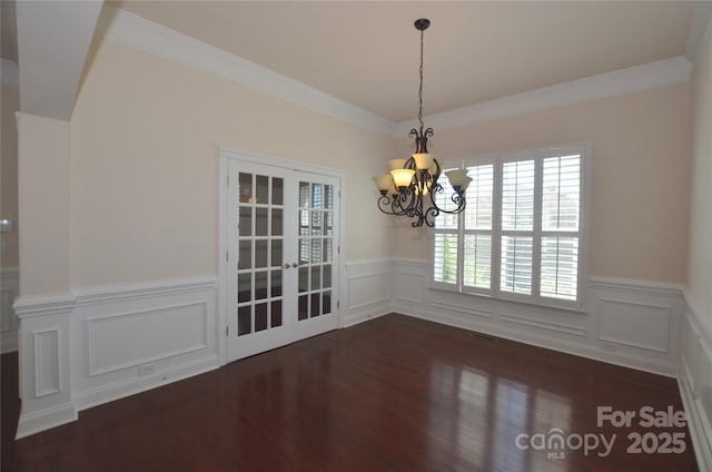 unfurnished dining area featuring a notable chandelier, french doors, crown molding, and dark hardwood / wood-style floors