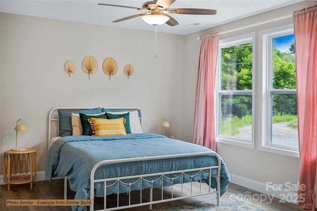 bedroom featuring ceiling fan, hardwood / wood-style floors, and multiple windows