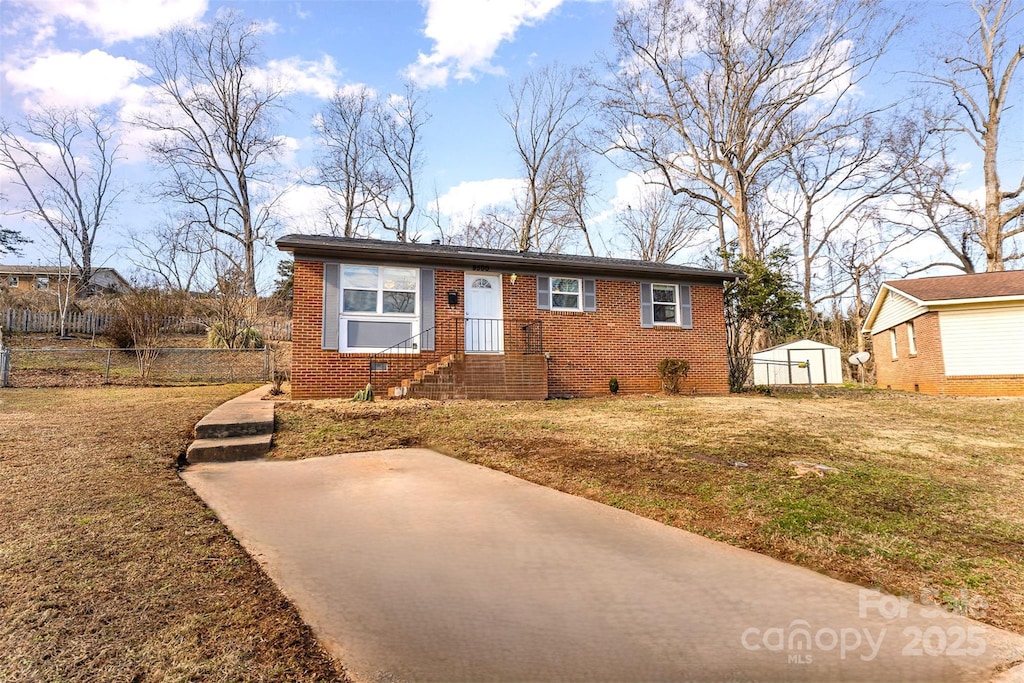 view of front facade featuring a front yard and a storage shed