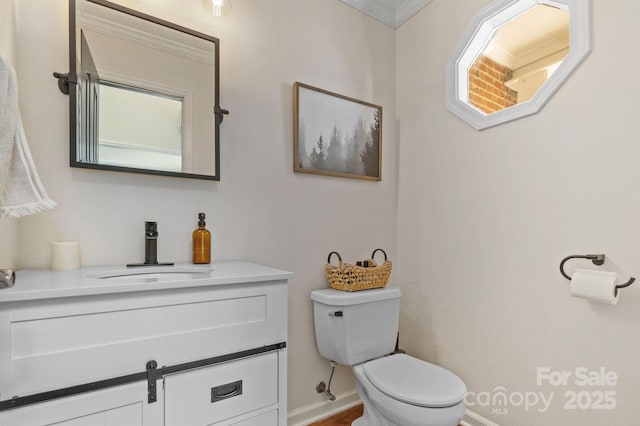 bathroom featuring ornamental molding, vanity, and toilet