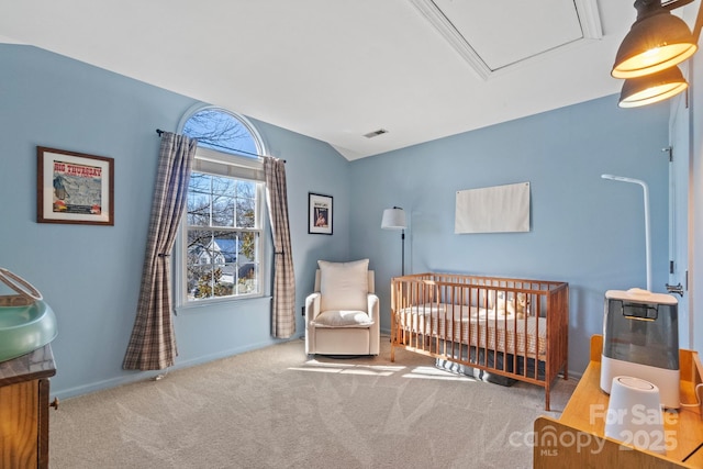 carpeted bedroom featuring a nursery area