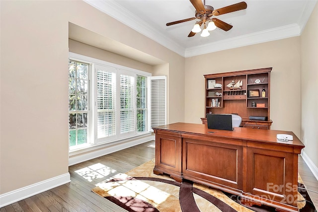 home office with ornamental molding, ceiling fan, and light wood-type flooring