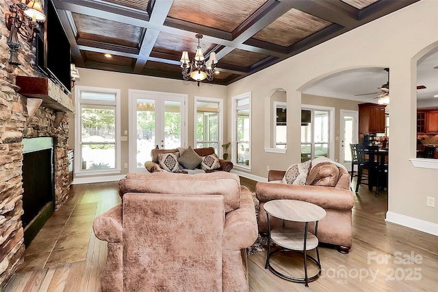 living room with crown molding, beam ceiling, coffered ceiling, ceiling fan with notable chandelier, and wooden ceiling