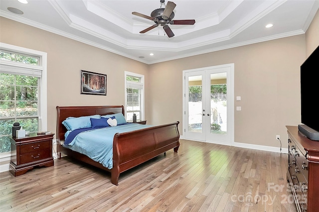 bedroom with french doors, light hardwood / wood-style flooring, a raised ceiling, ceiling fan, and access to exterior