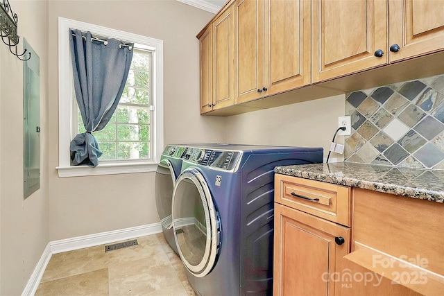 laundry area with cabinets, washing machine and dryer, plenty of natural light, and ornamental molding