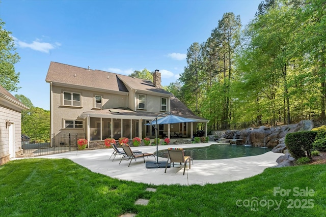 back of house featuring a patio, a yard, and a sunroom