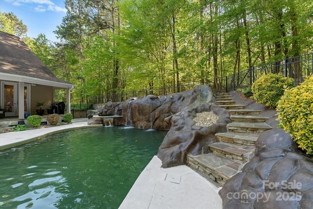 exterior space featuring pool water feature, a fenced in pool, and a patio