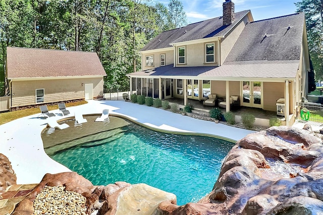 view of pool featuring a sunroom, outdoor lounge area, and a patio area