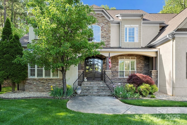 view of exterior entry featuring a yard and a porch