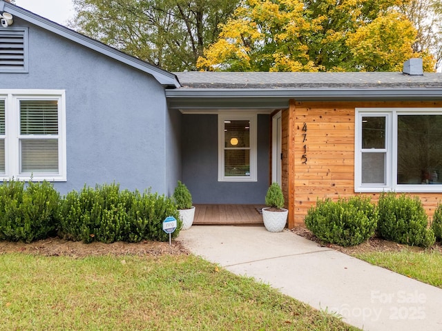 doorway to property with a lawn