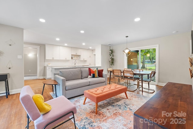 living room featuring sink and light hardwood / wood-style floors