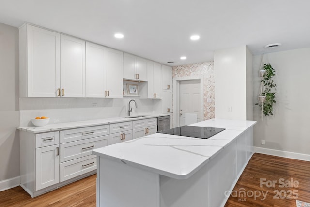 kitchen featuring white cabinetry, black electric stovetop, sink, stainless steel dishwasher, and light hardwood / wood-style flooring